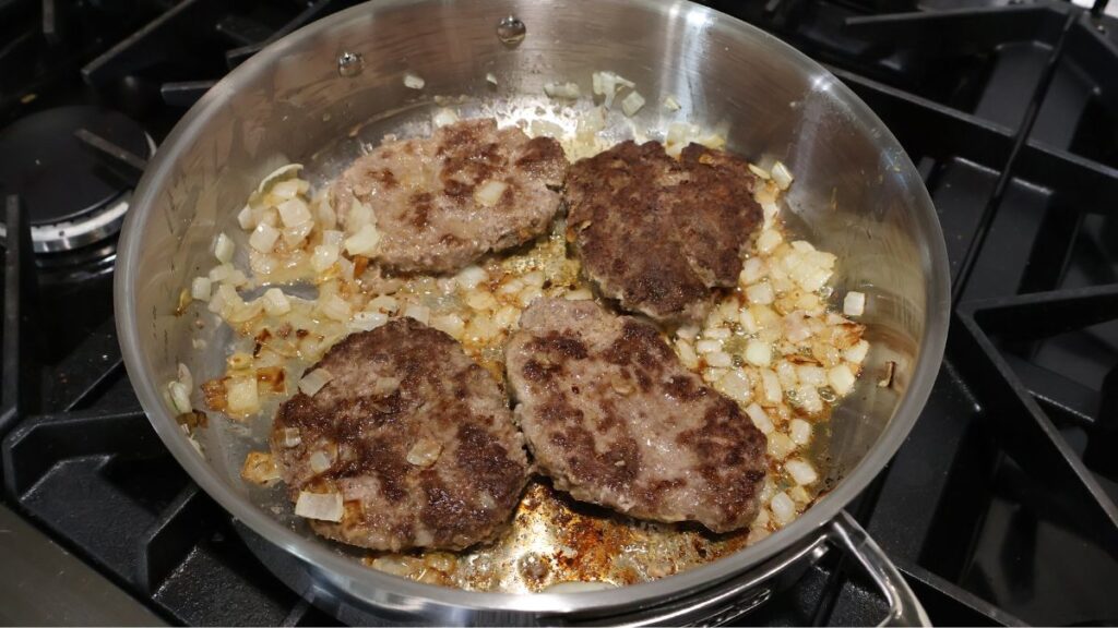 cooking hamburger steak patties in sauté pan