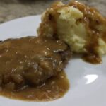 Salisbury steak on plate with mashed potatoes and gravy