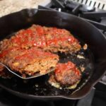 Meatloaf sliced to serve in cast iron skillet