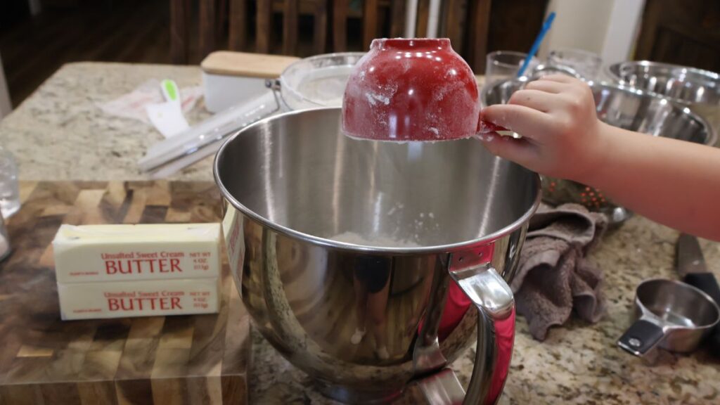 dumping flour into stand mixer bowl