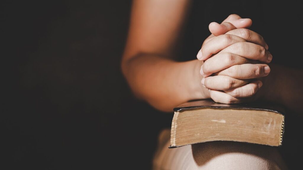 praying hands on Bible