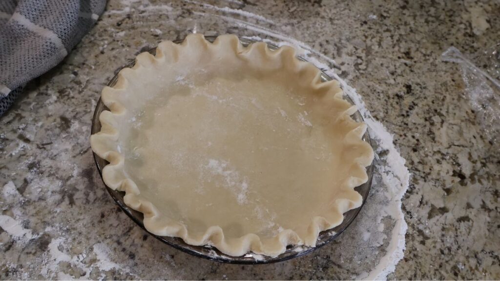 stand mixer pie crust raw in pie dish with crimped edges
