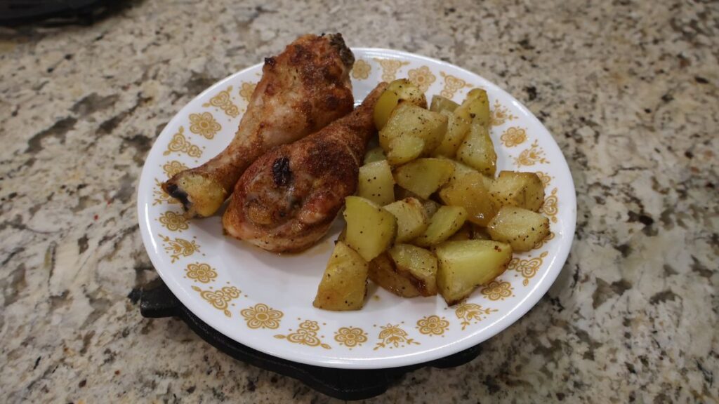 chicken legs seasoned with Farmhouse 181 seasoning on plate with roasted gold potatoes