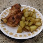 chicken legs seasoned with Farmhouse 181 seasoning on plate with roasted gold potatoes
