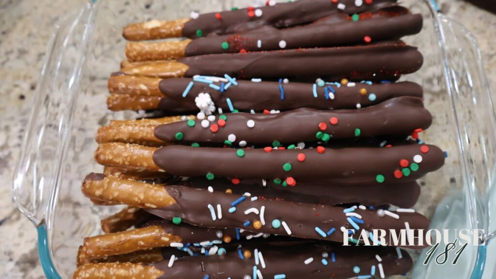pretzel rods with chocolate and sprinkles in glass container