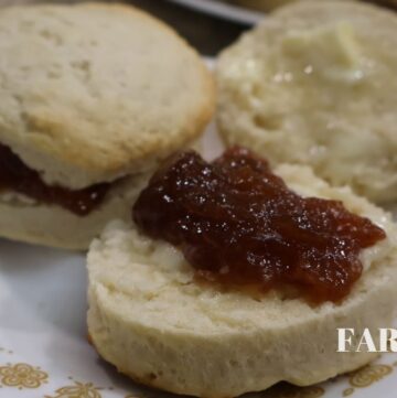 biscuits split open with butter and jelly placed on a plate