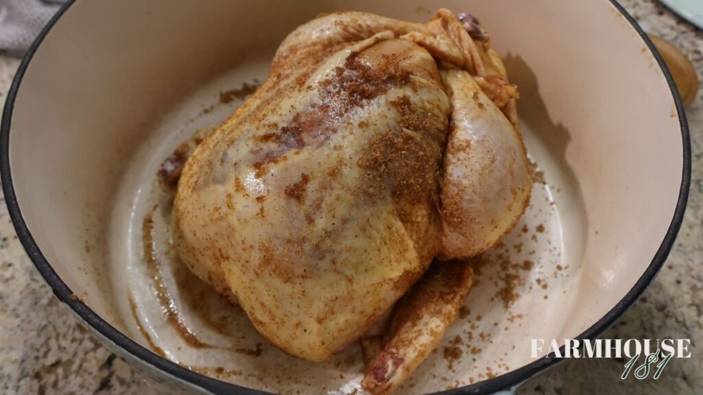 seasoned whole chicken in a cast iron dutch oven